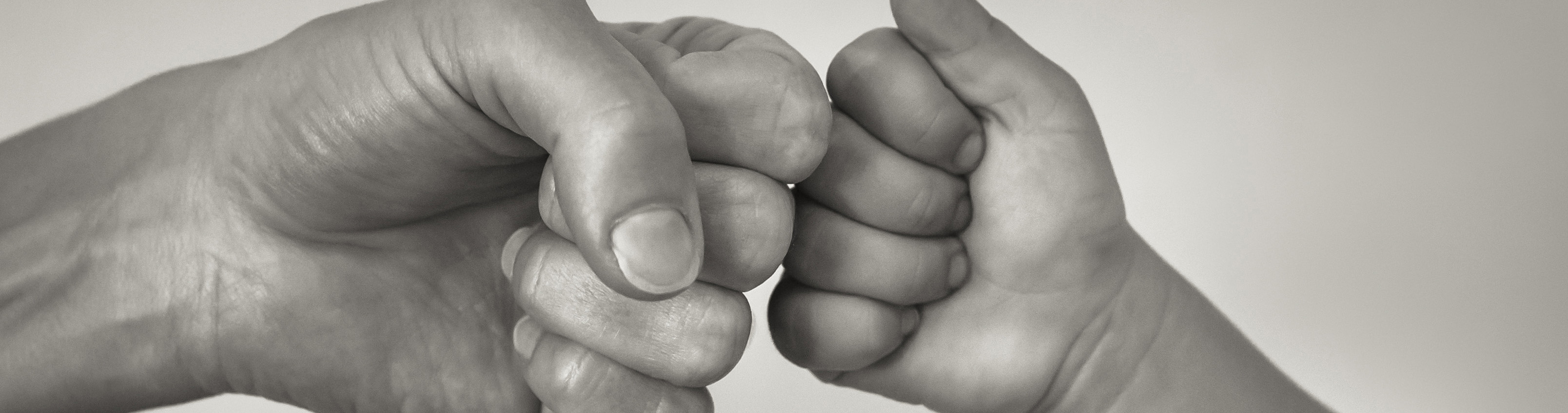 adult hand and child hand fist bump